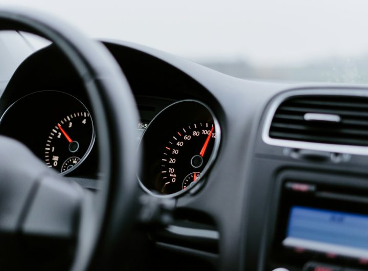 black vehicle dashboard with speedometer on 100
